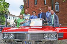 Volle Fahrt in den Spaß: Das Programm für das StadtFest Fehmarn wurde von Claudia Czellnik, Claus-Michael Rathjen, Andreas Joswig (jeweils Attraktive Altstadt e.V.), Tourismusdirektor Oliver Behncke, Friedrich Rathjen und Bürgermeister Jörg Weber mit einem Oldtimer von Anne Rossmann präsentiert.
