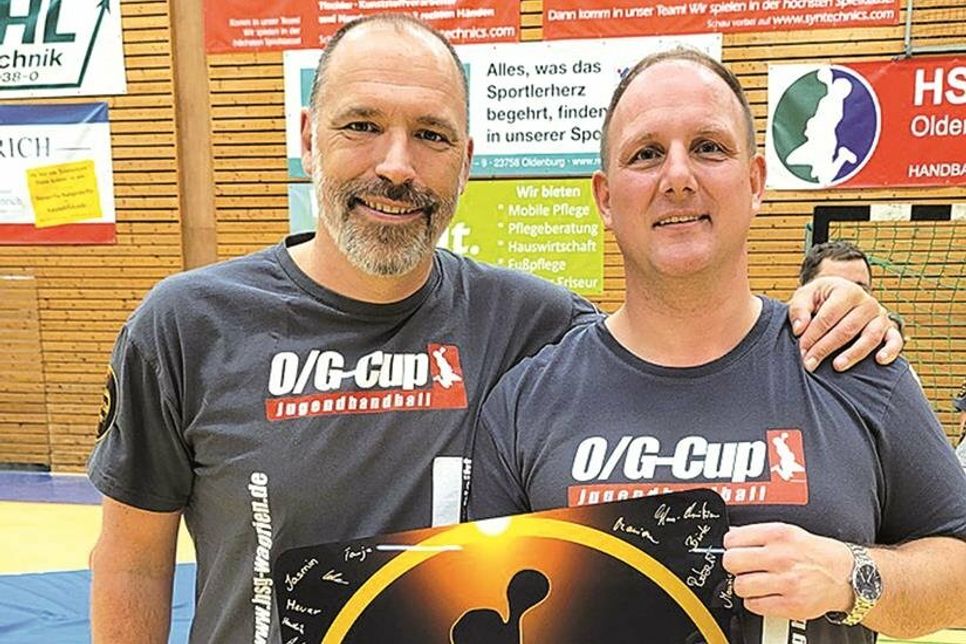 Dustin Homeyer (li.) überreicht Turnierleiter, Dominik Hollich, zum 10. O/G-Cup eine Jubiläumstafel mit Unterschriften des Orga-Teams.