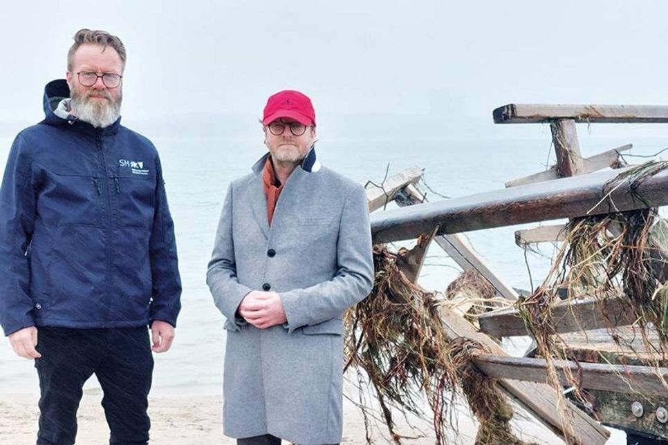 Wie hier an der zerstörten Molenbrücke in Niendorf, machten sich Tourismusminister Klaus Ruhe Madsen (l.) und Sven Partheil-Böhnke, Bürgermeister der Gemeinde Timmendorfer Strand, ein Bild von den Schäden, die die Sturmflut hinterlassen hat. Foto: hfr
