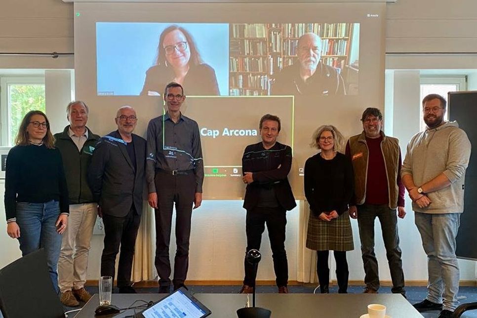 Dr. Verena Buser, Berlin, Jim G. Tobias, Nürnberg (zugeschaltet v. lks.); Julia Werner (Kuratorin Cap Arcona Dokumentationszentrum), Dr. Stephan Linck (Evangelische Akademie der Nordkirche), Dr. Reimer Möller (ehemaliger Leiter des Archivs der KZ-Gedenkstätte Neuengamme), Stefan Nies (Kurator Cap Arcona Dokumentationszentrum), Dr. Harald Schmid (Bürgerstiftung Schleswig-Holsteinische Gedenkstätten), Melanie Zühlke (pädagogische Mitarbeiterin Cap Arcona Museum), Prof. Dr. Norbert Fischer, Hamburg, Mirco Schlippes (Kulturabteilungsleiter der Stadt Neustadt und Projektleiter Cap Arcona Dokumentationszentrum) (stehend v. lks.).