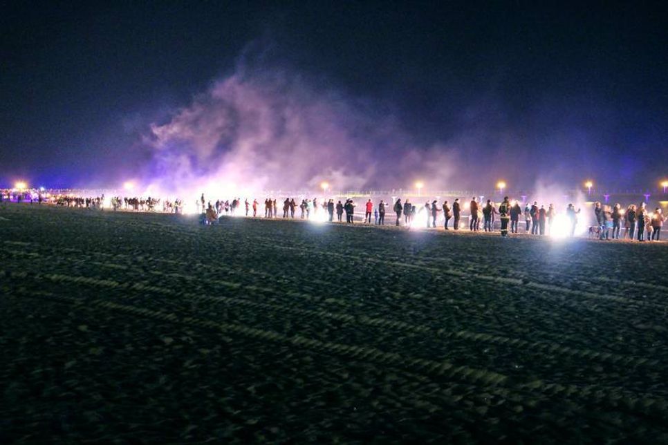 Als alle in Position waren, wurde die Menschenkette durch kleine Pyroeffekte beleuchtet.