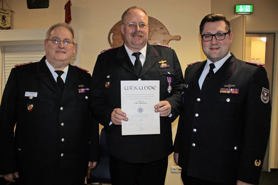 Ortswehrführer Hartmut Junge (lks.) und Beisitzer im Kreisfeuerwehrverband Alexander Wengelewski (re.) gratulierten Volker Buhrmann zur Verleihung des Schleswig-Holsteinischen Feuerwehrehrenkreuzes in Silber.