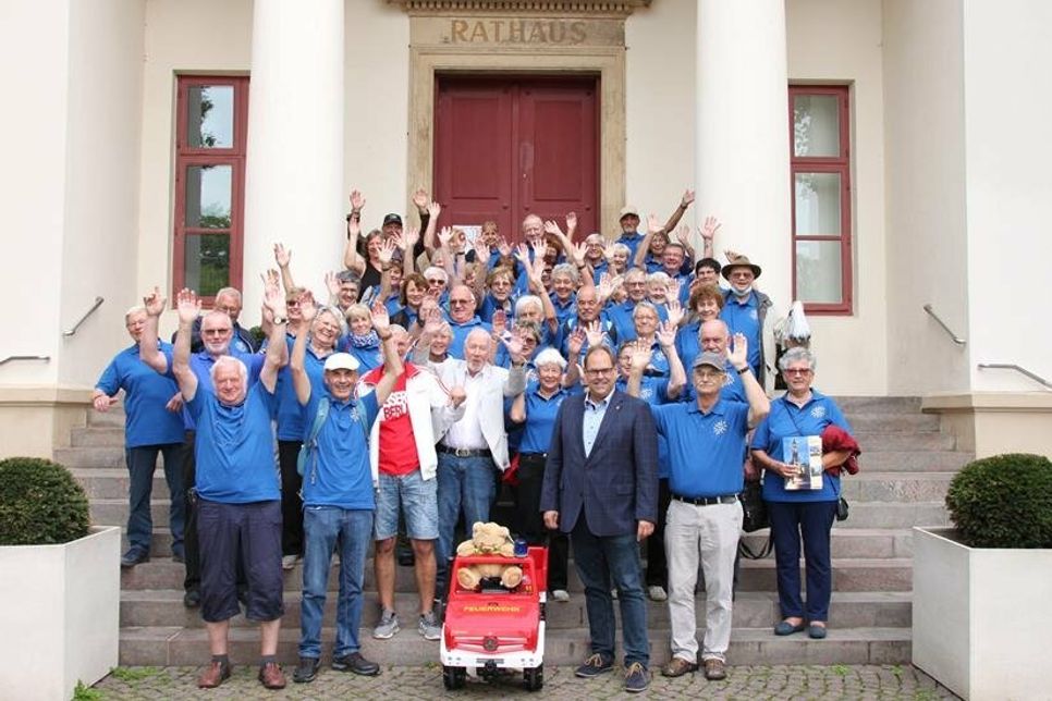 Die gut gelaunte Reisegruppe wurde von Bürgervorsteher Sönke Sela (unten Mitte) und Bürgermeister Mirko Spieckermann (3. v. re.) vor dem Rathaus in Empfang genommen.