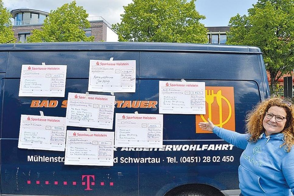 Auf dem Fahrzeug der Bad Schwartauer Tafel präsentierte die Initiatorin der Aktion Claudia Winter die Spendenschecks.