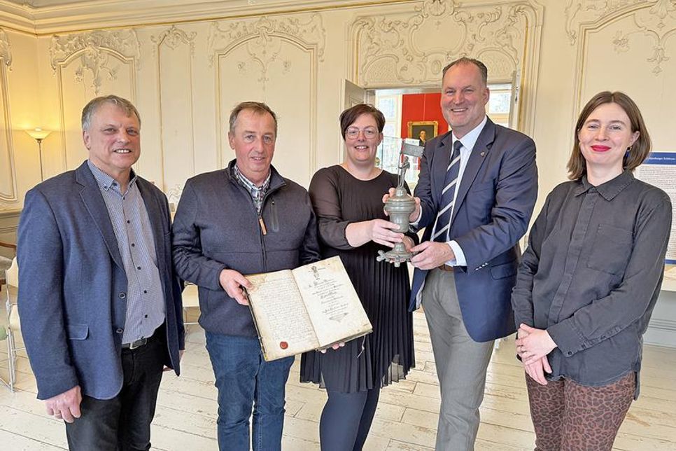 Großer Bahnhof für historisches Gefäß: Das Plöner Kreismuseum ist um ein neues Fundstück reicher. Die stellvertretende Leiterin der Plöner Fielmann-Filiale Jana Burchert (Mitte) überreichte den Trinkpokal aus Zinn jetzt an den Vorsitzenden des Museumsvereins, Björn Demmin. Ersteigert hatte ihn Fielmann-Kunsthistorikerin Dr. Constanze Köster. Gildeoberst Dirk Timmermann und Bürgermeister Dirk Sohn (l.) vertraten die Lütjenburger Schützen-Todtengilde, in deren Fundus sich der „Willkomm“ Anfang des 18. Jahrhunderts befunden hatte.