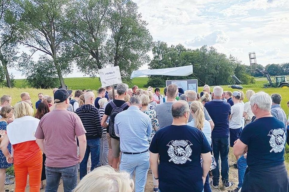 Rund 100 Einwohner aus Groß Timmendorf, zahlreiche Hunde und einige Gemeindevertreter sind zur Protestaktion erschienen. Banner und Traktor verdeutlichen vor Ort die Ausmaße des künftigen, sieben Meter hohen Bahndamms.