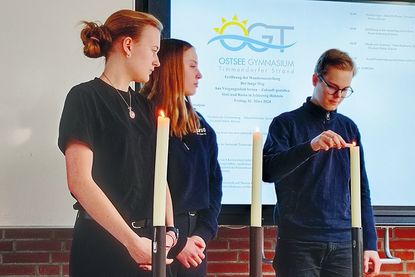 Bei der feierlichen Ausstellungseröffnung zündeten Schülerinnen und Schüler vor einer Schweigeminute Kerzen für die während des Nationalsozialismus ermordeten Sinti und Roma an.