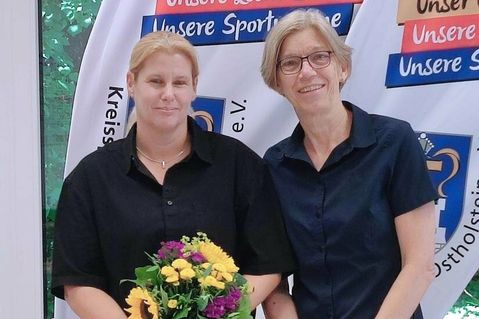 Die Vorsitzende des KSV Ostholstein, Birgit Kamrath Beyer (re), begrüßt Melanie Lindau mit einem Blumenstrauß.