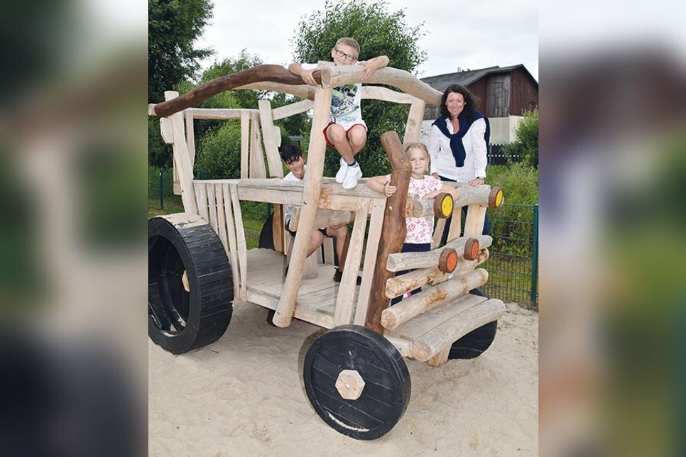Aiko (11), Lennox (10) und Milena (5) erobern den Traktor auf dem neuen Spielplatz, sehr zur Freude von Bürgermeisterin Bettina Schäfer.