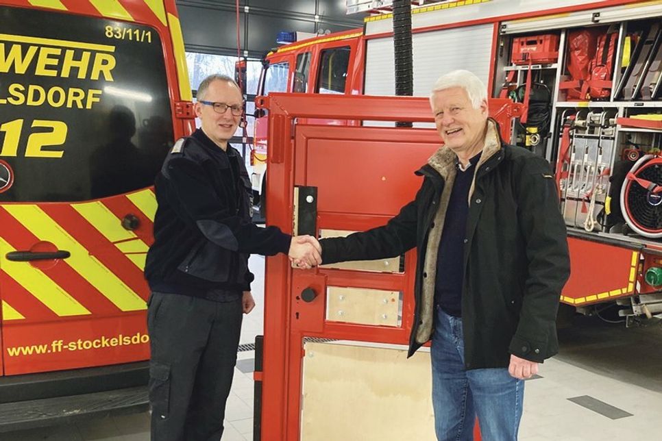 Andreas Gurth von der Friedrich Bluhme und Else Jebsen-Stiftung aus Stockelsdorf bei der Übergabe der Übungstür für Notfalltüröffnungen an Stockelsdorfs Wehrführer Christoph Dornheim.