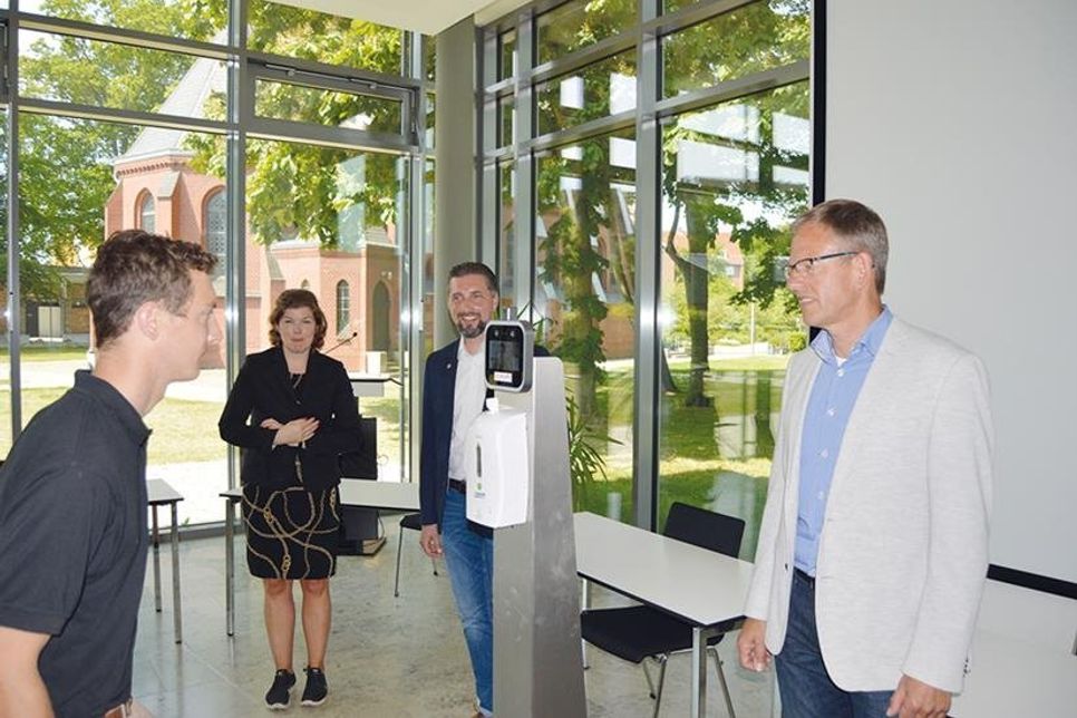 Nico Federsel (l.) aus dem Entwicklungsteam von „VisiConsult“ demonstriert vor seinem Chef Hajo Schulenburg (r.), Druckguss Service-Geschäftsführer André Dylon und ­Sto­ckelsdorfs Bürgermeisterin Julia Samtleben, wie der Temperatur-Scan funktioniert.