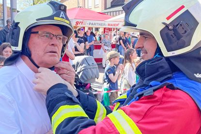 Passt das? Ein Feuerwehrmann hilft dem schwedischen Bürgermeister beim Schließen des Helms. Sicherheit geht vor, wenn Peter Egardt auf der Drehleiter in die Lüfte schwebt.