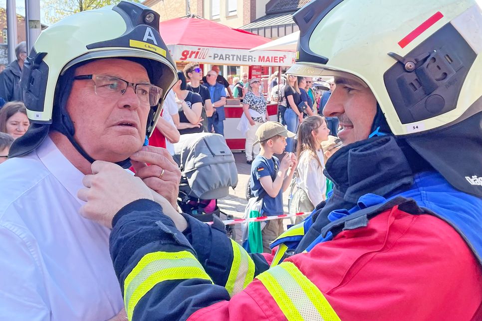 Passt das? Ein Feuerwehrmann hilft dem schwedischen Bürgermeister beim Schließen des Helms. Sicherheit geht vor, wenn Peter Egardt auf der Drehleiter in die Lüfte schwebt.