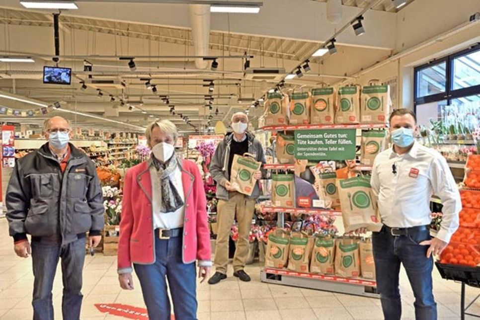 Tütenweise Lebensmittel für die Tafelkunden: Tafel-Vorsitzende Renate Beck, Beiratsmitglied Reiner Wilhelm (v. l.), Schatzmeister Jürgen Weiser und REWE Marktleiter David Schnibben freuen sich über die große Unterstützung und Hilfsbereitschaft in der Schusterstadt.