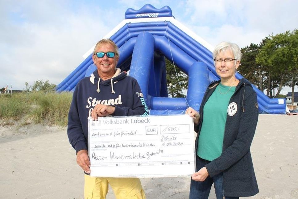 Heiko Neuhoff und Dagmar von Holdt, Beisitzerin der Lübeck-Hilfe für krebskranke Kinder, vor der Riesen-Wasserrutsche.