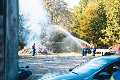 In  der Nähe eines Waldgebietes war ein Holzhaufen in  Brand geraten und musste schleunigst gelöscht werden.