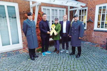 Die Eutinerin Christine Dunker-Kobza übergibt im Beisein von Kompaniechef Hauptmann Max Adrian (li.) und „Spieß“ Oberstabsfeldwebel Dirk Reichenbach (re.) die gelbe Schleife an Bürgermeister Thomas Keller (2.v.li.) und Bürgervorsteher Daniel Thomaschewski.