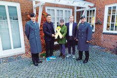 Die Eutinerin Christine Dunker-Kobza übergibt im Beisein von Kompaniechef Hauptmann Max Adrian (li.) und „Spieß“ Oberstabsfeldwebel Dirk Reichenbach (re.) die gelbe Schleife an Bürgermeister Thomas Keller (2.v.li.) und Bürgervorsteher Daniel Thomaschewski.