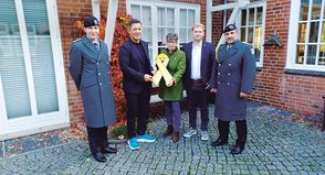 Die Eutinerin Christine Dunker-Kobza übergibt im Beisein von Kompaniechef Hauptmann Max Adrian (li.) und „Spieß“ Oberstabsfeldwebel Dirk Reichenbach (re.) die gelbe Schleife an Bürgermeister Thomas Keller (2.v.li.) und Bürgervorsteher Daniel Thomaschewski.