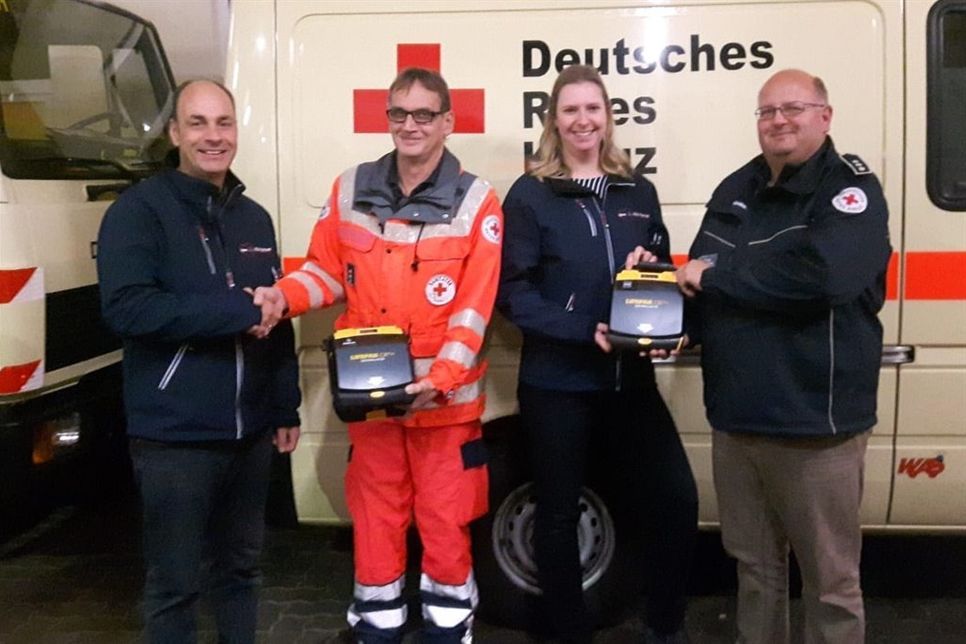 Sven Salewski (2. v. lks.) und Jan Kruse (re.) von der DRK-Bereitschaft Neustadt nahmen die neuen AED-Geräte von Kay Cyriacks (lks.) und Licz Heidecke (2. v. re.) entgegen.