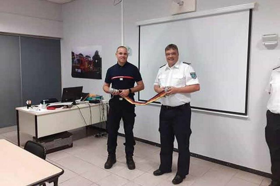 Übergabe des symbolischen Freundschaftsschlauchs an den Kommandanten Mathieu Cabelguen durch den Gemeindewehrführer André Hasselmann.