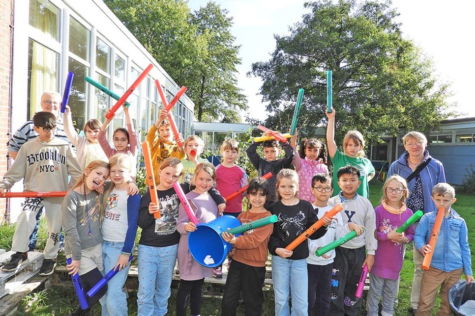 Die Klasse 3d nahm stellvertretend für die gesamte Gustav-Peters-Schule die Auszeichnung für das Projekt „Müllfreie Schule“ von Iris Bruhn (hinten rechts) entgegen. Zum Dank gab es ein Ständchen mit Boomwhackers-Begleitung.
