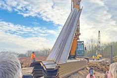 An der Straßenböschung wird zurzeit eine Spundwand in den Boden gerammt.