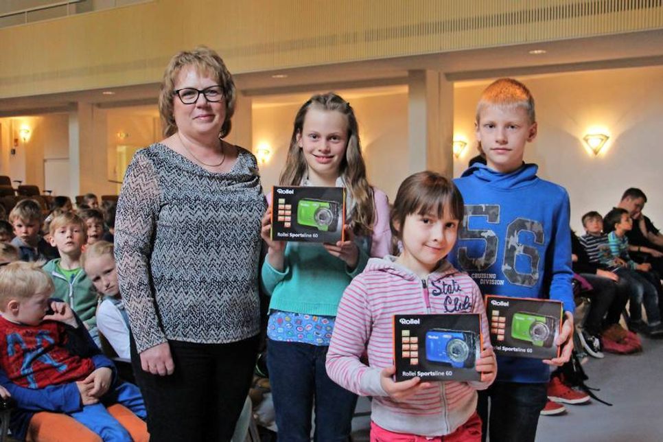 Martina Schmidt von der Sparkasse Holstein mit den Gewinnern der Unterwasserkameras Lieke John, Katharina Tock und Noah Hornig (v. lks.).