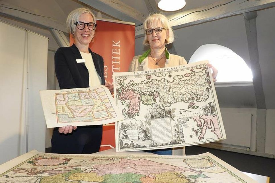 Faszination in Gehalt und Form: Claudia Freutel, Leiterin der Fielmann-Niederlassung in Eutin, und Karten-Expertin Susanne Hatscher mit den drei neuerworbenen historischen Landkarten.