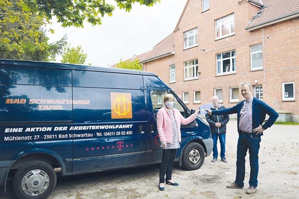 Im Beisein des Awo-Vorsitzenden Wolfgang Dunker (m.) übergibt Hans-Harald Schack aus dem KoKi-Vorstand die Kinogutscheine an Monika Vechtel, Tafel Bad Schwartau.