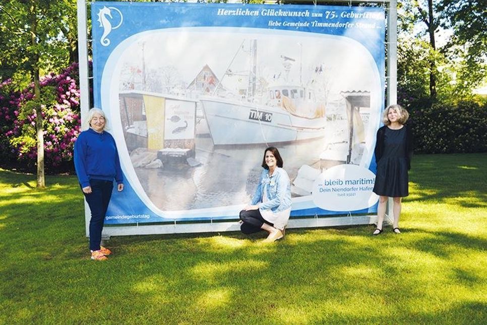 Sie haben sich für den gelungenen XXL-Geburtstagsgruß ordenlich ins Zeug gelegt: Timmendorfs Gemeindearchivarin Melanie Zühlke (r.), Grafik-Designerin Stephanie Scheel (li.) und Silke Szymoniak von der TSNT.