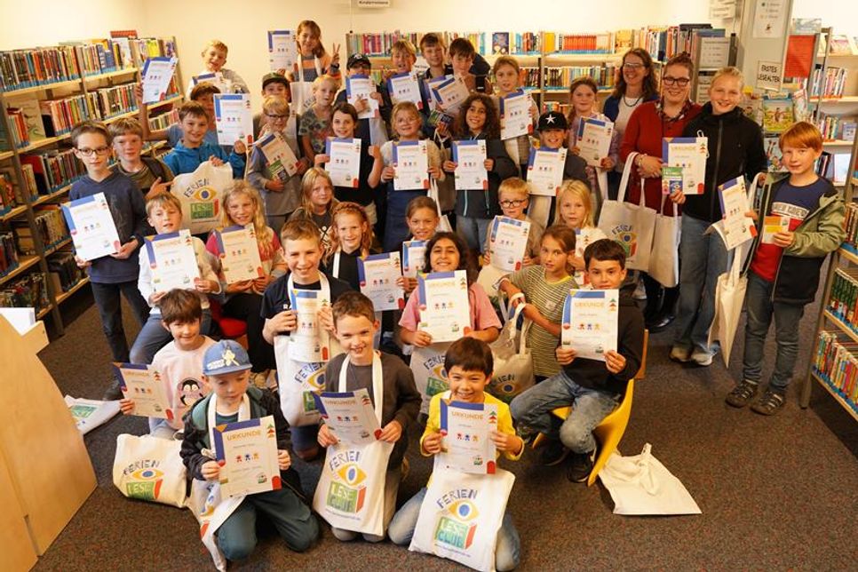 Stolz zeigen die Kinder ihre Urkunde vom FerienLeseClub.