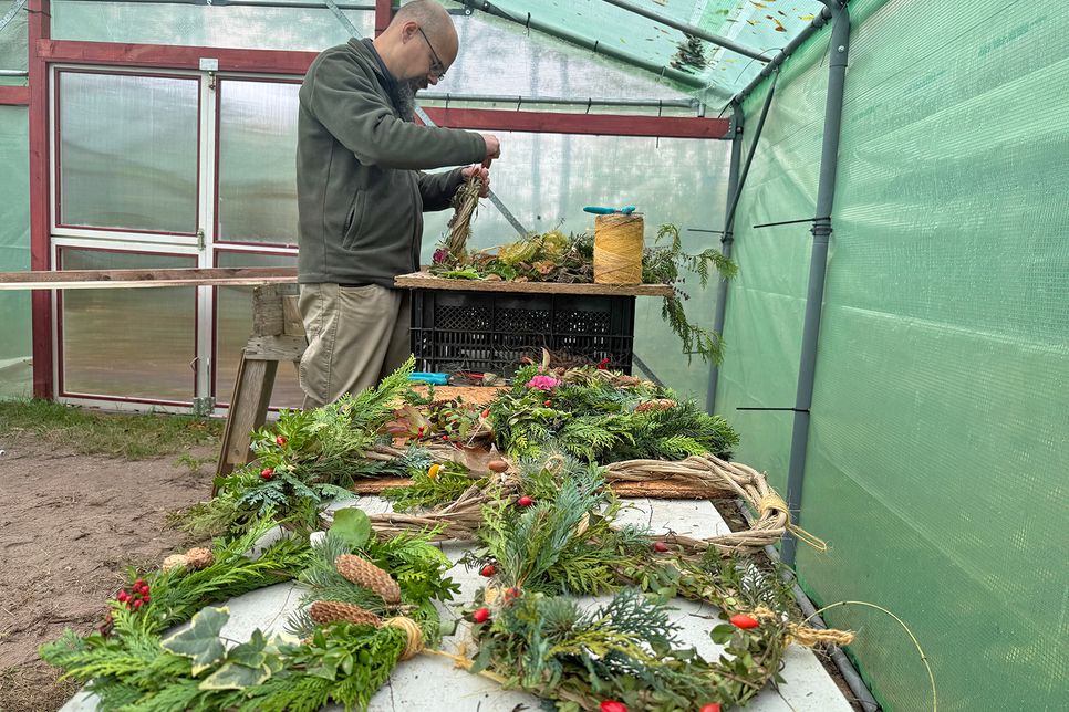 In der Gartenbauabteilung stellt Dennis Fahrenkrog Kränze her.