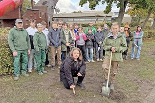 Gruppenbild mit Mitarbeitern der GaLa-Bau-Firma „Smid“ aus Plön und einigen der aktiven Schüler: Alle hoffen, dass die Frühblüher im April sprießen.
