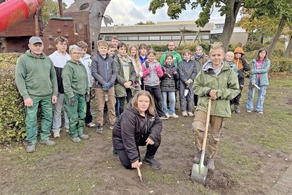 Gruppenbild mit Mitarbeitern der GaLa-Bau-Firma „Smid“ aus Plön und einigen der aktiven Schüler: Alle hoffen, dass die Frühblüher im April sprießen.