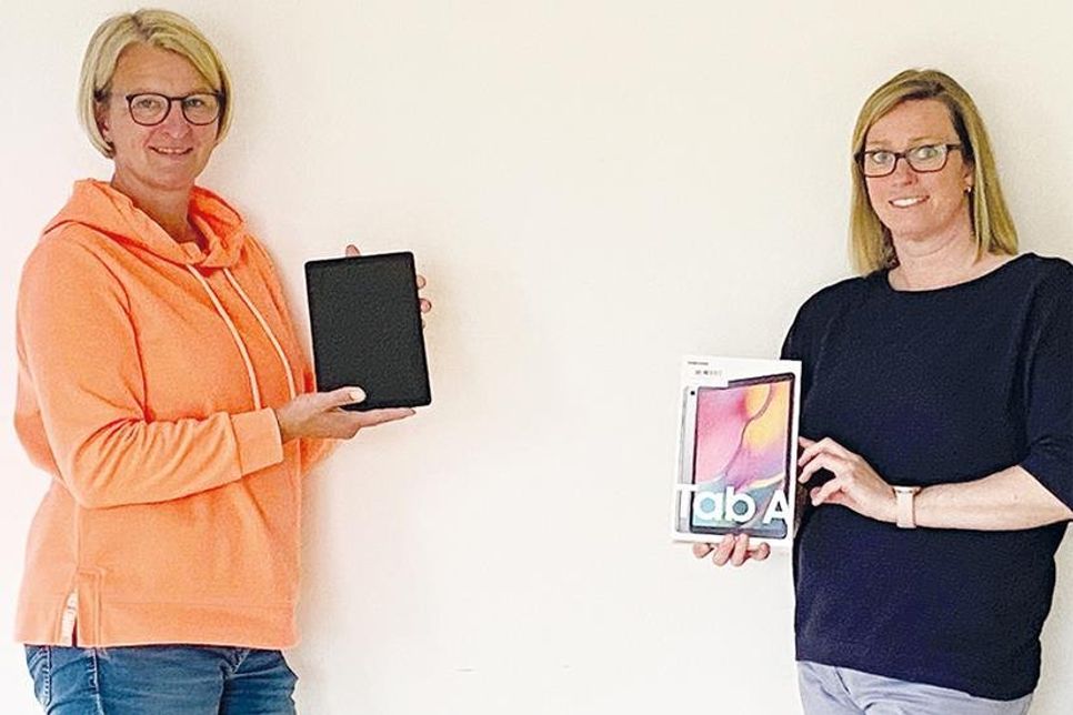 Melanie Müller (links), Leiterin der Kindertagesstätten „Am Papenmoor“ und „Langenfelde“ und Nadine Müller von „Frühe Hilfen“ der Lebenshilfe Ostholstein mit den Tabletts, die durch eine Spende angeschafft werden konnten.