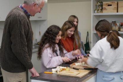 Olaf Knickrehm (Geschäftsführer Passader Backhaus) lässt sich von Schülerinnen der Produktionsgruppe des Profilzweigs Theos Wiese die Zubereitung von Kimchi für den eigenen Verzehr zeigen.
