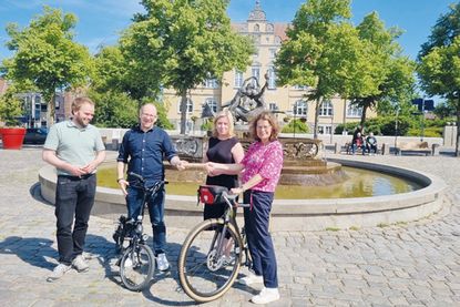 Bad Schwartaus Bürgermeisterin Dr. Katrin Engeln (re.) nimmt zusammen mit Stadtpräsidentin Wiebke Zweig und Thies Fellenberg (li.), Klimaschutzmanager der Stadt Bad Schwartau, den Staffelstab von Jan Karthäuser, 3. Stellvertreter des Bürgermeisters der Gemeinde Timmendorfer Strand, entgegen.
