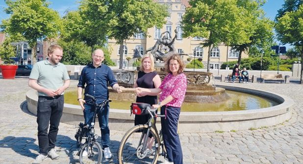 Bad Schwartaus Bürgermeisterin Dr. Katrin Engeln (re.) nimmt zusammen mit Stadtpräsidentin Wiebke Zweig und Thies Fellenberg (li.), Klimaschutzmanager der Stadt Bad Schwartau, den Staffelstab von Jan Karthäuser, 3. Stellvertreter des Bürgermeisters der Gemeinde Timmendorfer Strand, entgegen.