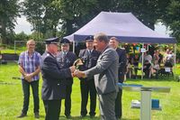 Der stellvertretende Landrat Karsten Alwast überreichte im Namen des Kreises Ostholstein die bronzene Glocke an Wehrführer Heiko Stölck.