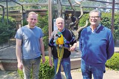Vogelpark-Betreiber Klaus Langfeldt mit dem ältesten Bewohner des Parks, Ara Peter (über 70 Jahre alt), und sein Partner Massimo Menghini (rechts) mit ihrem Nachfolger Christian Siebelts (links), der den Vogelpark am 2. August offiziell übernimmt.