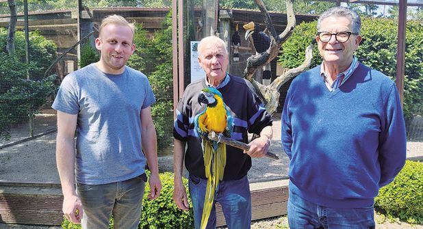 Vogelpark-Betreiber Klaus Langfeldt mit dem ältesten Bewohner des Parks, Ara Peter (über 70 Jahre alt), und sein Partner Massimo Menghini (rechts) mit ihrem Nachfolger Christian Siebelts (links), der den Vogelpark am 2. August offiziell übernimmt.