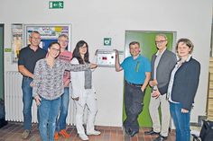 Fünf der zehn Sponsoren, Peter Marquardt, Firma Grammerstorf Sanitär-Heizung, (v.li.), Melanie Brede (Bäckerei Brede), Andreas Leffler (Fahrschule Leffler), Maren Musfeldt (Tischlerei Rahn) und Oliver Nowitzki (Glaserei Nowitzki), mit Schulleiter Michael Bartolf und Lehrerin Corinna Möller vor dem gespendeten Defibrillator.