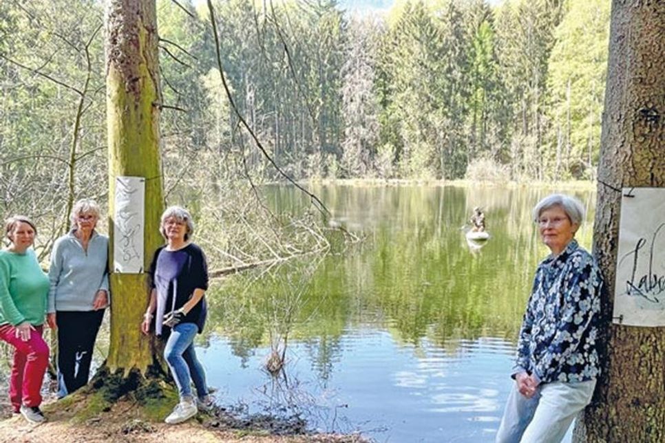 Kulturliebhaber*innen blüht etwas im Dersauer Eichholz: Ilse Phillippsen, Roswitha Richter, Frederike Leiber und Anne Gabriel und der Künstler Ulf Reisener (auf dem Sup bei der “Installation” der schwimmenden Wasserskulptur) haben das Grün in eine Freiluft-Galerie verwandelt. Besucher können ihnen zum Beispiel vergessene Wörter zukommen lassen, diese werden auf Lesezeichen geschrieben und aufgehängt, so dass sich der Wald nach und nach füllt.