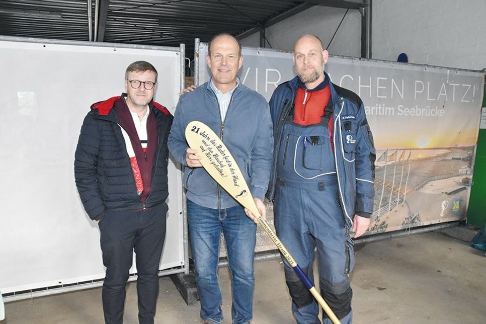 Ein „goldenes Paddel“ zum Abschied von Rüdiger Helm (Mitte), hier mit Bürgermeister Sven Partheil-Böhnke und dem stellvertretenden Bauhofsleiter Sven Petersen (rechts).