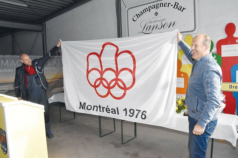 Aus den Händen von seinem langjährigen Stellvertreter Sven Petersen erhielt der dreifache Olympiasieger Rüdiger Helm einen Original-Nachdruck der Olympia-Flagge von 1976.