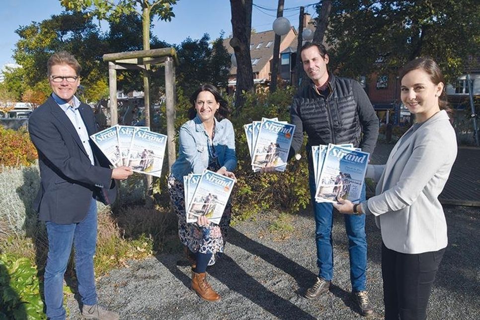 Tourismuschef Joachim Nitz (links), Marketingleiterin Silke Szymoniak und Hannah Block (Marketingabteilung der TSNT GmbH, rechts) präsentieren mit Henrik Fels von der ausführenden Agentur das neue Strandmagazin 2021.