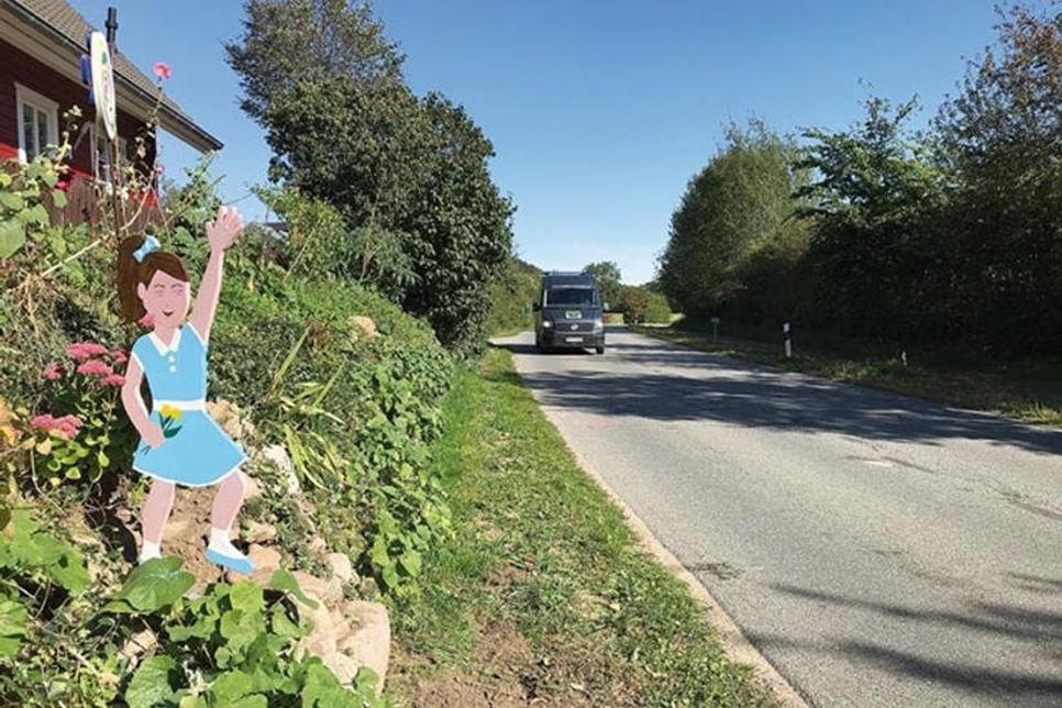 Am Ortsausgang winkt ein Blumenmädchen und macht so die Autofahrer auf die Kinder in Quisdorf aufmerksam.