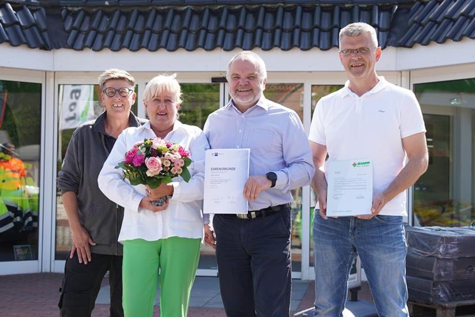 Angela Langfeldt (2. v. lks.) wurde mit Blumen, Geschenken und lieben Worten für das 25-jährige Mitarbeiterjubiläum von Baucenterleiter Holger Werner (3. v. lks.) und den Kolleginnen und Kollegen geehrt.