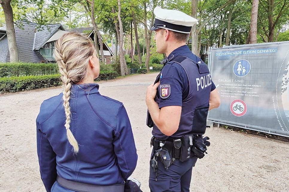Ordnungsdienstmitarbeiterin Bianca Streich und Polizeihauptmeister Jérôme Wardenga bei der gemeinsamen Radfahrkontrolle auf der Strandpromenade.